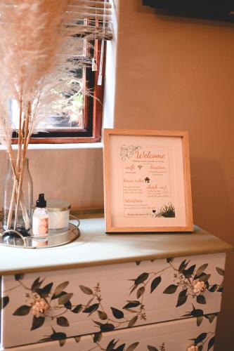 a picture frame sitting on top of a shelf with a window at The Red door in Rustenburg