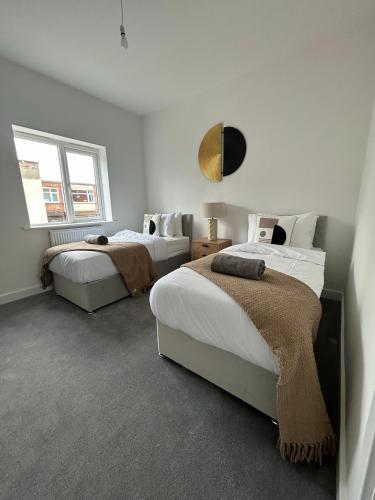 een slaapkamer met 2 bedden en een raam bij Free Parking! Comfy home in Barwell, Leicester -b- 