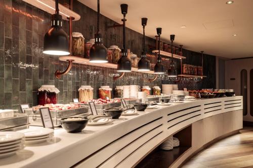 a buffet line with plates and utensils in a restaurant at Hilton Swinoujscie Resort And Spa in Świnoujście