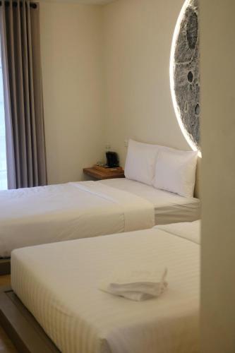 two beds in a hotel room with a mirror at Sora Boutique Stay in Ciwidey