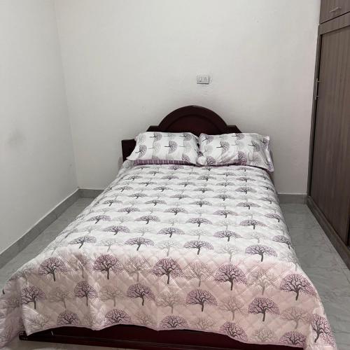 a bed with a pink comforter and pillows on it at Casa Familiar- Turística Manríque Medellín in Medellín