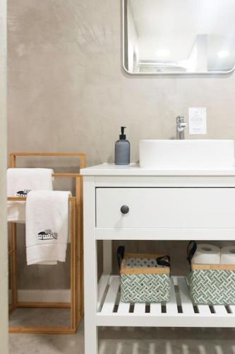 a bathroom with a white sink and a mirror at Casa do Pátio do Tejo N12 in Sarilhos Pequenos