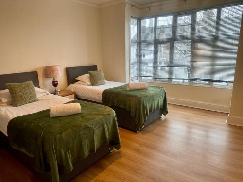 um quarto com duas camas e uma janela em Clare House - sleeps 14 em Bedford