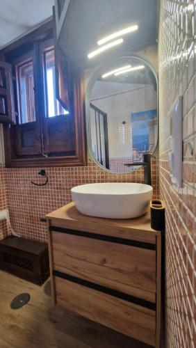 a bathroom with a white sink and a mirror at Apartamento EL TORMO DE CASA BOTES in Cuenca