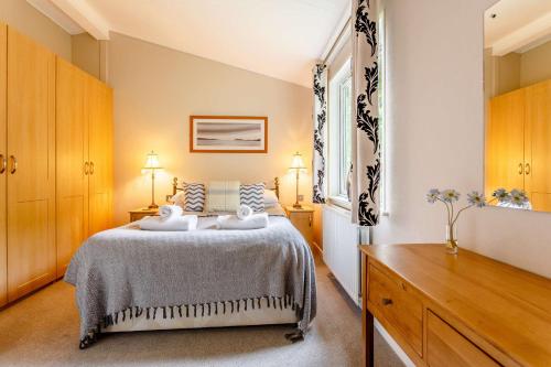 1 dormitorio con 1 cama con 2 toallas en Norton Lodge 18, en Kingham