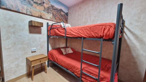 a room with two bunk beds and a table at Apartamento EL TORMO DE CASA BOTES in Cuenca