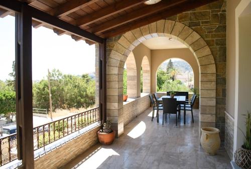 an outdoor patio with an archway and a table and chairs at Βίλα Μαρία Νεφέλη για μαγικές διακοπές στο νησί μας in Panormos Kalymnos