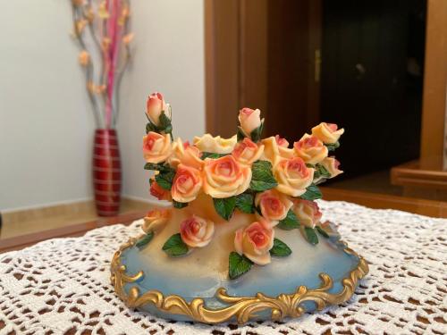 a cake with roses on top of a table at Guest House Persa in Gjirokastër