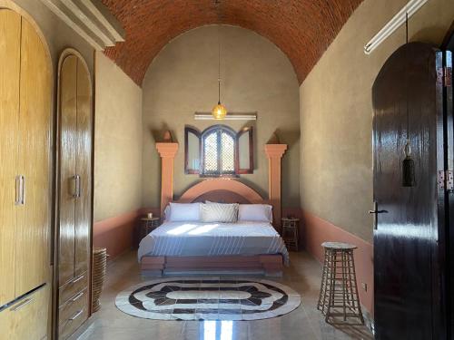 een slaapkamer met een bed in een kamer met een raam bij The Desert House, Luxor, Westbank in ‘Ezbet Abu Ḥabashi