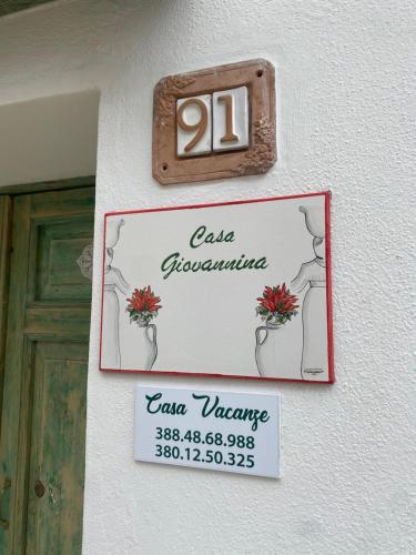 a sign on the side of a building with a door at Casa Giovannina in Bernalda