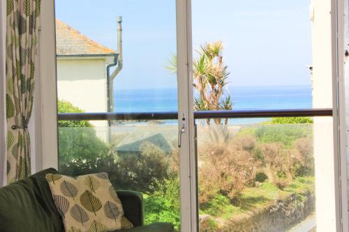 a window with a view of the ocean at STYLISH, BEACHSIDE apartment, sea views in St Merryn