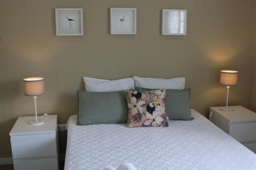 Un dormitorio con una cama con almohadas y dos lámparas. en RS Apartamento, en Quarteira