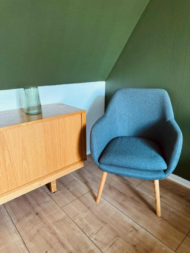 a blue chair sitting next to a wooden cabinet at KonceptHotel in Oksbøl