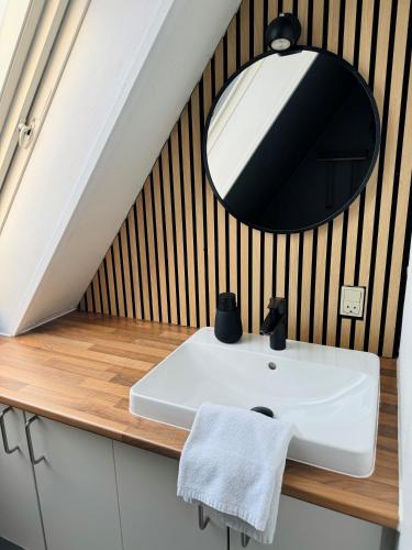 a bathroom with a white sink and a mirror at KonceptHotel in Oksbøl