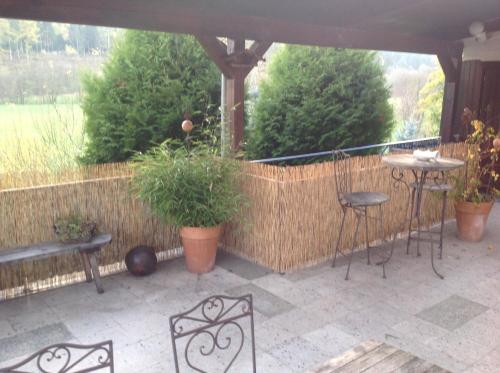 a patio with a table and chairs and a fence at Große, hundefreundliche Ferienwohnung mit großer Terrasse in Flussnähe in Medebach
