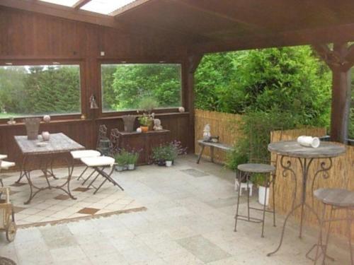 an outdoor patio with tables and chairs and windows at Große, hundefreundliche Ferienwohnung mit großer Terrasse in Flussnähe in Medebach