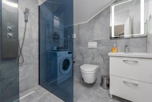 een badkamer met een douche en een wasmachine bij Villa Izvor in Bribir
