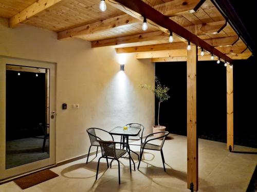 a patio with a table and chairs under a wooden ceiling at Cozy Owl's Studio Home in Pýrgos