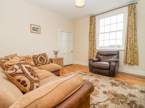a living room with a couch and a chair and a window at The Shires at Bickerscourt in Solihull