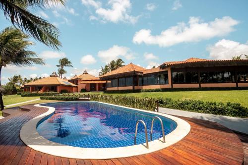 a swimming pool in front of a house at Pousada Tabapitanga in Porto De Galinhas