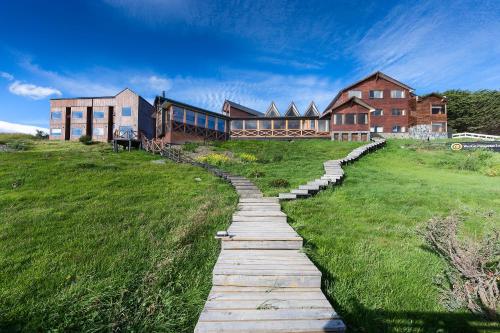 a stone path leading to a house on a field at Weskar Lodge Hotel in Puerto Natales