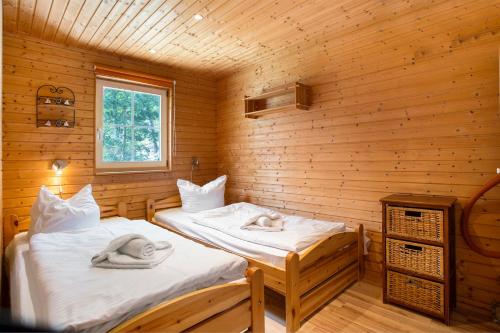 two beds in a log cabin with towels on them at Lillis Ferienhaus Nr 27 in Göhren