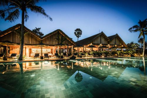 ein Resort mit Pool in der Nacht in der Unterkunft Zannier Phum Baitang in Siem Reap
