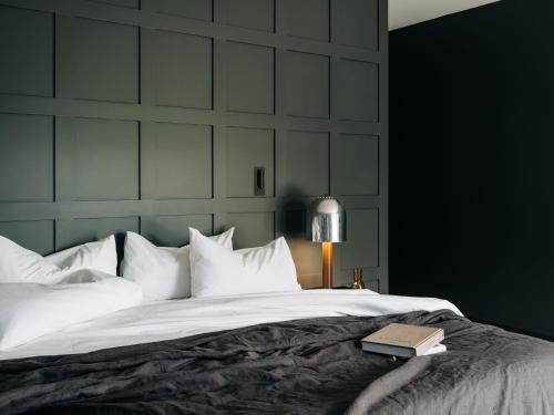 Un dormitorio con una cama con un libro. en Moody Luxury Home in the Wine Region, en Richmond