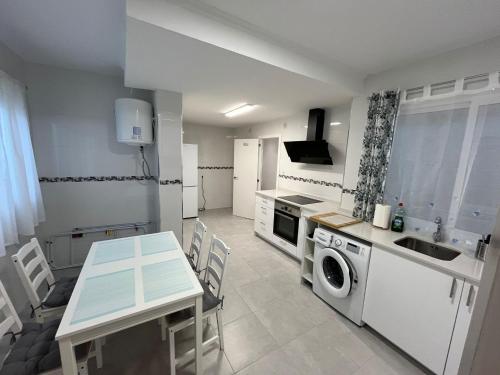 a kitchen with a table and a sink and a stove at Europa Moderna Apartamento in Gandía