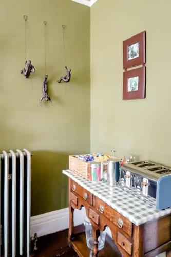 a kitchen with a table with a stove and a radiator at Victorian Guest House 200m from the Seafront in West Kirby