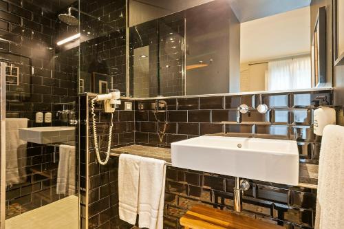 ein Bad mit einem Waschbecken und einem Spiegel in der Unterkunft Uma Suites Pau Claris in Barcelona