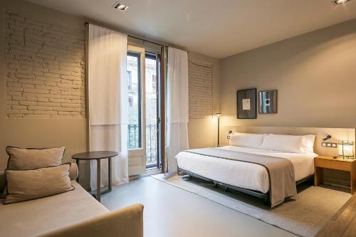 ein Schlafzimmer mit einem großen Bett und einem Fenster in der Unterkunft Uma Suites Pau Claris in Barcelona