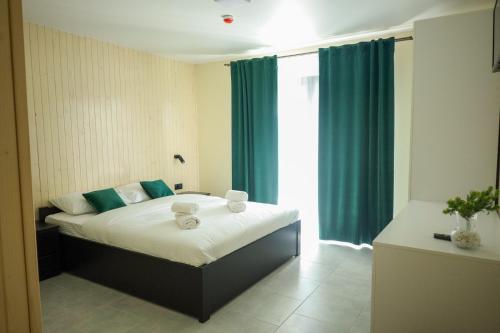 a bedroom with a bed with blue curtains and a window at VERANDA in Solotvyno