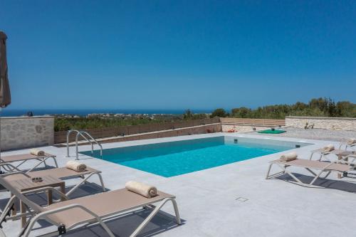 a swimming pool with two lounge chairs and a swimming pool at Meli & Gio 2 in Viranepiskopí