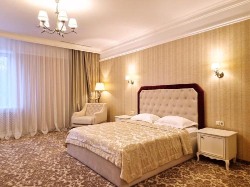 ein Schlafzimmer mit einem großen Bett und einem Stuhl in der Unterkunft Hotel Misto SPA & FITNESS in Kharkov