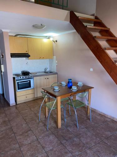 a kitchen with a table and two chairs and a stove at Μεζονέτα AIKATERINI N 17 in Chios
