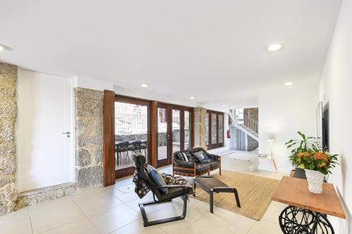 a living room with chairs and a table at Quinta Rolim do Bouro By Sé Apartamentos in Roucio