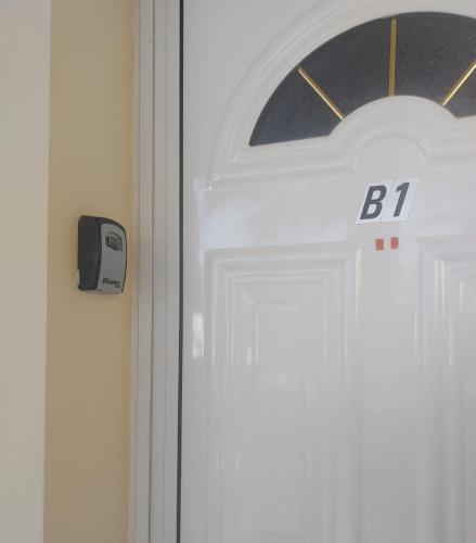 a white door with the letter on it at MyCyprusStay - Jo's Cosy 1 Bedroom Apartment in Paphos City