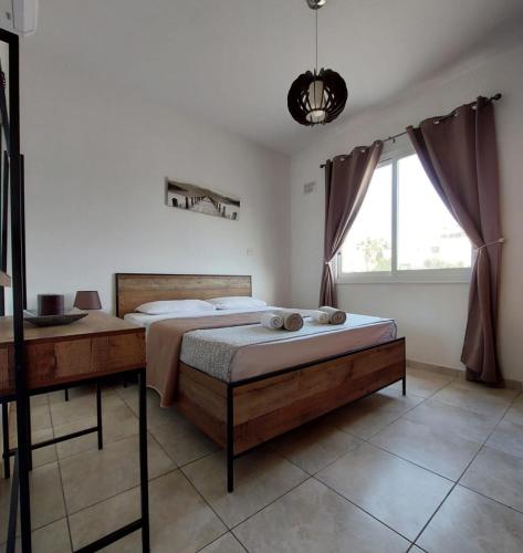 a bedroom with a large bed and a window at MyCyprusStay - Jo's Cosy 1 Bedroom Apartment in Paphos City