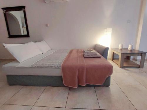 a bedroom with a bed with a table and a mirror at MyCyprusStay - Jo's Cosy 1 Bedroom Apartment in Paphos City