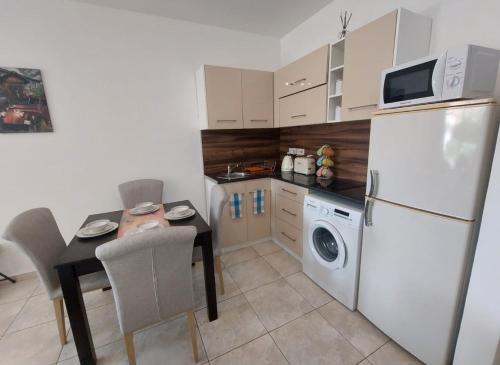 a kitchen with a white refrigerator and a table with chairs at MyCyprusStay - Jo's Cosy 1 Bedroom Apartment in Paphos City