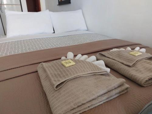 a bed with two towels on top of it at MyCyprusStay - Jo's Cosy 1 Bedroom Apartment in Paphos City