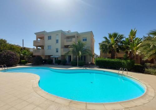a large swimming pool in front of a building at MyCyprusStay - Jo's Cosy 1 Bedroom Apartment in Paphos City