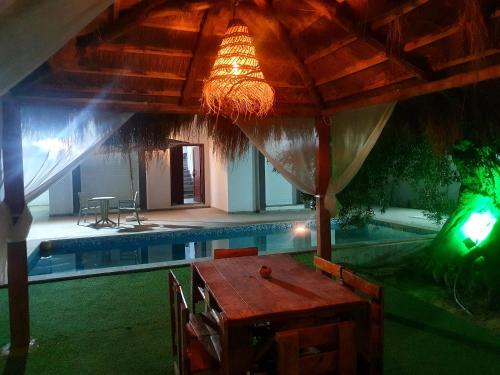 a house with a pool and a table with a chandelier at Villa de luxe avec piscine privée sans vis à vis à Djerba in Aghīr