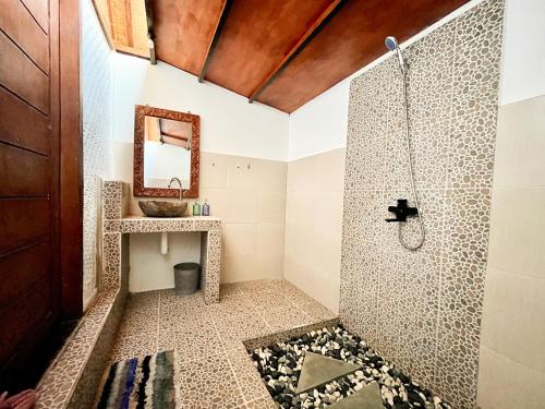 ein Bad mit einer Dusche und einem Waschbecken in der Unterkunft Little Bear Bungalows in Gili Air