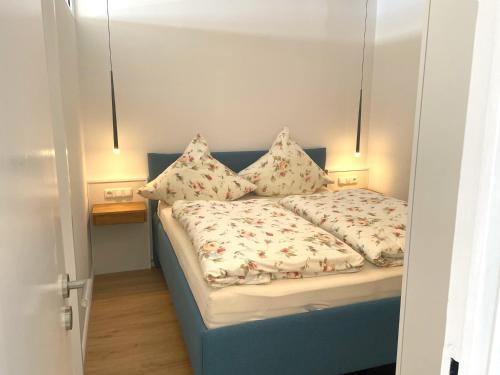 - une chambre avec un lit bleu et des oreillers dans l'établissement Panoramic Auszeit mit Meerblick, à Sierksdorf
