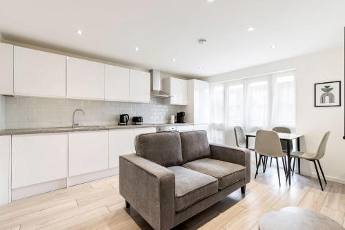 cocina y sala de estar con sofá y mesa en Finsbury Park Retreat Modern Comfort, en Londres