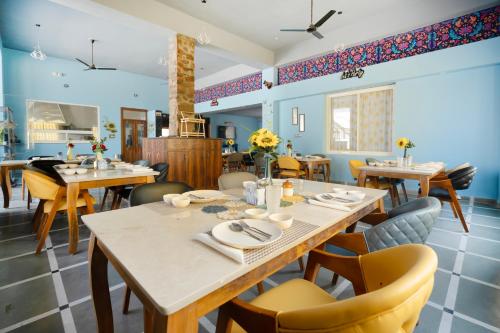 une salle à manger avec des tables et des chaises en bois dans l'établissement Sunflower Saga, à Jaipur