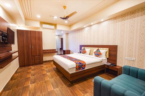 sypialnia z łóżkiem i niebieską kanapą w obiekcie FabHotel Grand Falcon w mieście Bengaluru