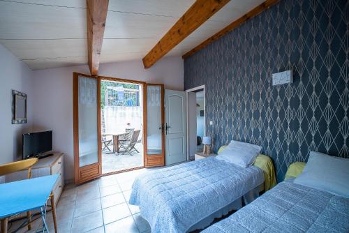 a bedroom with two beds and a tv and a window at Maison Le Boulou - Grand jardin piscine privée in Le Boulou